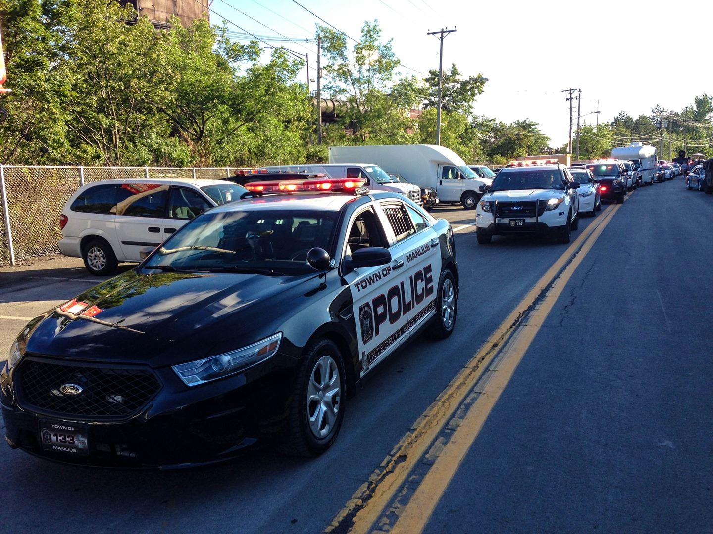 A line of vehicles drive down the road